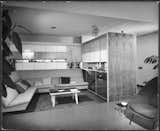 This photo from 1950 shows the living room alcove with a custom built-in sofa, cupboards, and cabinetry.