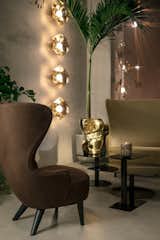 Cut surface lights in gold illuminate new Flash tables in black and a Wingback sofa and chair.