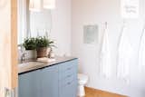 A peek inside the guest bathroom. Hygge Supply custom-designed the home's cabinets, vanities, and islands. The pendant lights are from Color Cord.