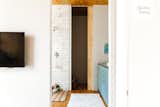 The toilet is concealed behind a wooden sliding door in the master bath. 