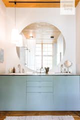 Hygge Supply designed the large, circular mirror and the custom vanity with Delta fixtures.