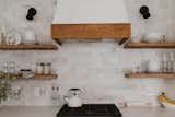 An Italian marble backsplash complements the open shelving made from reclaimed wood purchased from local Amish shops.