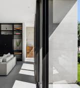 Black aluminum door frames stand out against the concrete structure and sandblasted marble floors. 