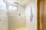 Subway tiling wraps around the enclosed shower, while operable windows provide airflow without compromising privacy.