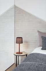 Bedroom, Night Stands, Bed, Table Lighting, and Medium Hardwood Floor The Vipp table lamp ($259) that features a perforated metal lampshade and pull string.   Photos from Vipp’s Newest High-Design Hotel Outpost Is in a Water-Pumping Station