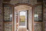 Doors, Swing Door Type, Interior, and Wood The entrance sequence begins with a metal staircase that leads up to the first-floor entrance hall with a coat cupboard and bathroom.   Photos from Own a Brilliantly Converted Brick Fortress in England For $1.5M