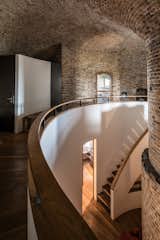A curved staircase descends to the ground-floor bedrooms. 