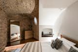Bedroom, Dresser, and Bed Light wells cut into the nearly 10-foot-wide masonry walls let daylight into the bedrooms, which were formerly used as storage rooms.  Photo 9 of 16 in Own a Brilliantly Converted Brick Fortress in England For $1.5M
