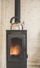 The Werkstattofen wood stove, which can be found in hardware stores across Northern Europe, transfers heat quickly and can heat the cabin up in less than 15 minutes. Not pictured is the double-layered metal sheeting that wraps around the stove for fire protection. 