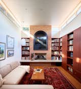 Remotely operable clerestory windows under the raised roof allow more natural light and airflow. A new fireplace and shelving were also added; the central hearth mimics the design of the cantilevered front balcony. The original midcentury Herman Miller sofa and coffee table were given to the new owners and reupholstered.