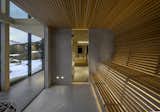 The sauna interior is lined with hygroscopic aspen slats. One-way glass separates the sauna from the hallway and provides views out into the landscape. 