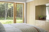 The bedrooms feature custom ash millwork, while large windows invite views of the outdoors in.