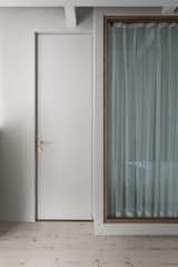 Pictured here is the door to the bathroom. White curtains inside the bathroom provide privacy.