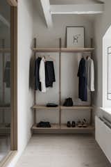 Custom Frama shelving provides space for a minimalist wardrobe.