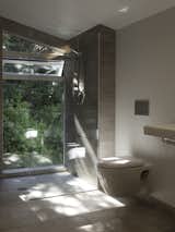 Full-height glazing in the bathroom gives the impression of showering in the bush.