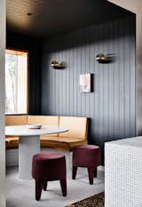 The vertical timber paneling that encloses the dining nook is painted in Dulux Domino.