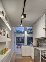 The minimalist kitchen is outfitted with Corian countertops. The floors throughout are bleached oak. 