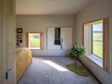 The master bedroom overlooks views of the fields. Folding wooden screens were installed in place of curtains. 