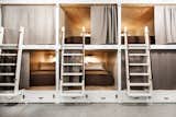 The bunk beds were built from painted millwork, beadboard, and plywood with walnut handrails and unlacquered polished brass hardware. Sturdy, ergonomic ladders provide access to the top bunks.
