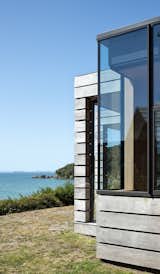 The home is clad in reclaimed swamp totara that helps blend the silver-toned building into the dunes. The cladding is mounted on custom Perspex for easy maintenance. 