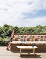 The outdoor bench is covered with Maharam fabric. The surfboard coffee table was built by one of the client’s sons. 