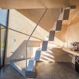 A space-saving staggered steel staircase leads up to the loft with a bedroom and bathroom.