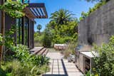 Exterior, House Building Type, Prefab Building Type, Flat RoofLine, and Wood Siding Material The wooden deck wraps around the L-shaped home. Tall walls and thick vegetation shroud the home in privacy.   Photo 11 of 15 in Will Arnett Lists His Prefab-Hybrid Home in Beverly Hills for $11M