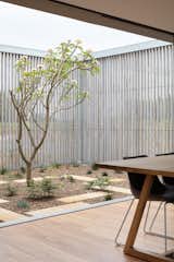 The courtyard functions as an outdoor room framed by a pair of timber screens.