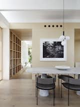 A Nuura Miira 4 pendant light hangs above the custom one-ton marble dining table surrounded by Era dining chairs by Living Divani from Space Saving Furniture Australia. The framed photograph is by Paul Ogier. 