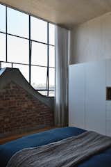 The master bedroom faces a wall of south-facing glass and the top of the Dutch gable. 