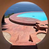 Elliptical and circular openings throughout the home frame views of the Mediterranean. 