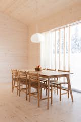 The dining area is furnished with refurbished Danish chairs from the 1970s, an oak table purchased from a local store called Jysk, and a Muuto Fluid pendant lamp.