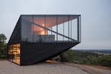 The sharply angular home matches the aesthetic of Fundo Puertecillo’s other blackened timber–clad houses, some of which were also designed by 2DM.