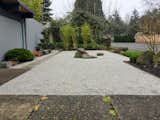 Concrete slabs lead to a side gate, taking you past a specialty pruned black pine.