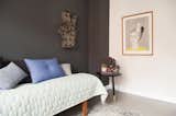 Bedroom, Bed, Night Stands, and Medium Hardwood Floor Bedroom with mint quilt, slate colored wall, and peace sign lighted art  Photo 1 of 8 in Minimalist Nordic Flat by Petra Ford