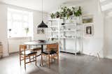 Contemporary Scandinavian dining room with round black table and metal open shelving