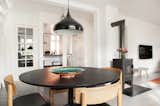 Open dining room featuring black table, wood chairs, and black metal pendant light