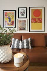 Detail of leather sofa and wall of artwork 
