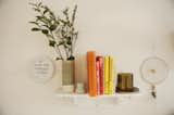 Decorative shelf holding colorful books and flowers