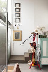 Vertically positioned artwork and mirrors draw the up in the high-ceilinged entryway