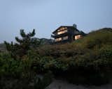 As the house sits atop a cliff on the beachfront, its dwellers can enjoy views of the sandy dunes below.
