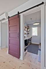 Minimizing swinging doors maximizes space and adds character with this vintage 5-panel door used in a barn door style.