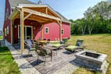 Exterior Timber framed covered patio with stamped concrete and custom build fire pit.  Photo 7 of 35 in The Red Barn Home by Mottram Architecture