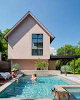 The ADU, finished in a light pink stucco, anchors the pool and courtyard.