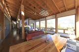 Locally sourced timber and the regular structure of post-and-beam organize the house throughout. Exposed rafters and natural larch ceilings add warmth.