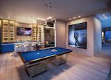A uniquely designed club room is complete with a pool table, antique bar, and a plush home theater.