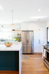 Kitchen, Engineered Quartz Counter, White Cabinet, Drop In Sink, Ceramic Tile Backsplashe, Range, Medium Hardwood Floor, Recessed Lighting, Pendant Lighting, and Refrigerator  Photo 2 of 8 in 24 House Remodel by Tagliaferri Architects, Inc