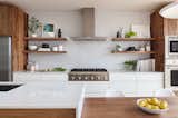The Heath Ceramics wall tile backsplash was extended to full height and behind floating shelves to add texture and character to the minimal kitchen.