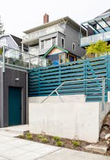 A new garage is nestled into the hillside and painted with pops of color. 