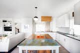 A comprehensive remodel to this traditional kitchen allows for natural light and accommodates the chefs with custom, new cabinetry, storage and a salvaged, customized island. 